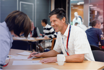 To personer som sitter ved et bord og ser på ark 