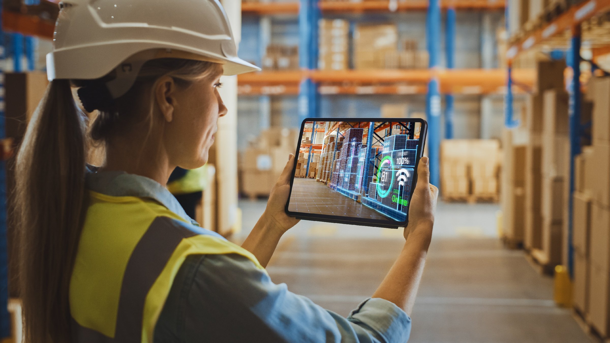 Kvinne bruker digital twin supply chain warehouse reality-applikasjon på et nettbrett.